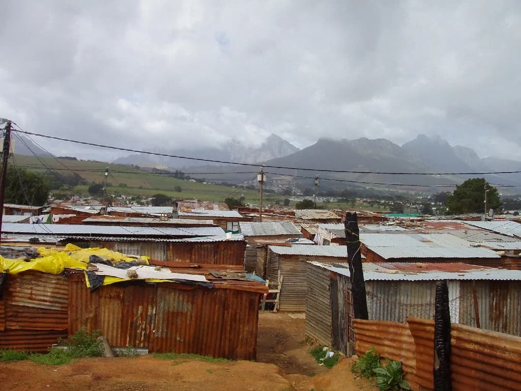 Kayamandi's corrugated-iron roofs under low cloud, the Boland mountains behind