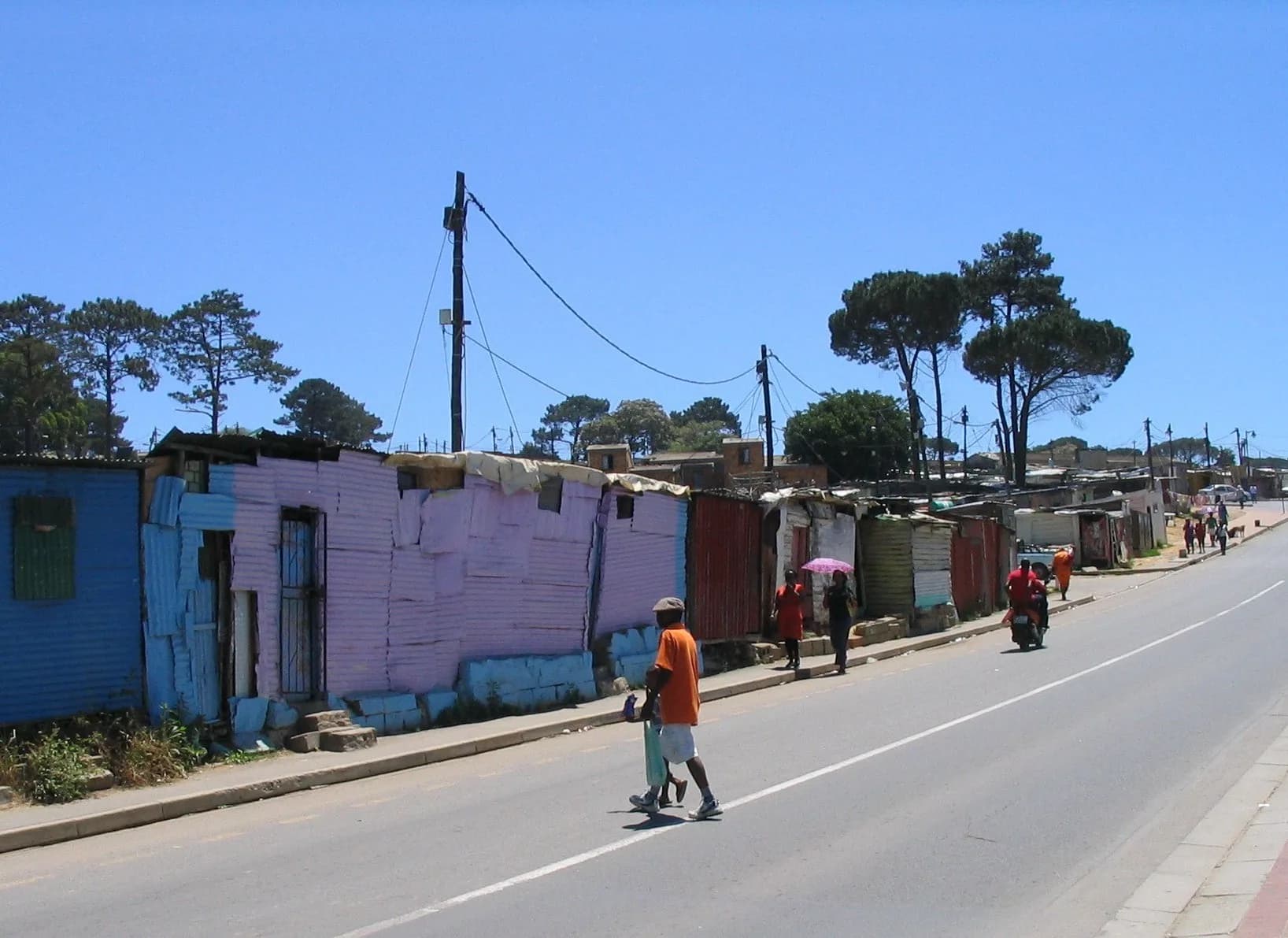 A woman walking home along a Kayamandi street in the late afternoon
