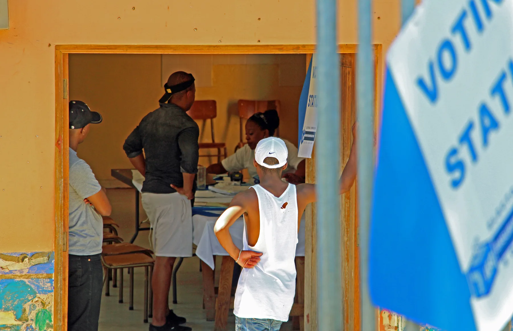 Residents being helped at a registration desk inside a community hall