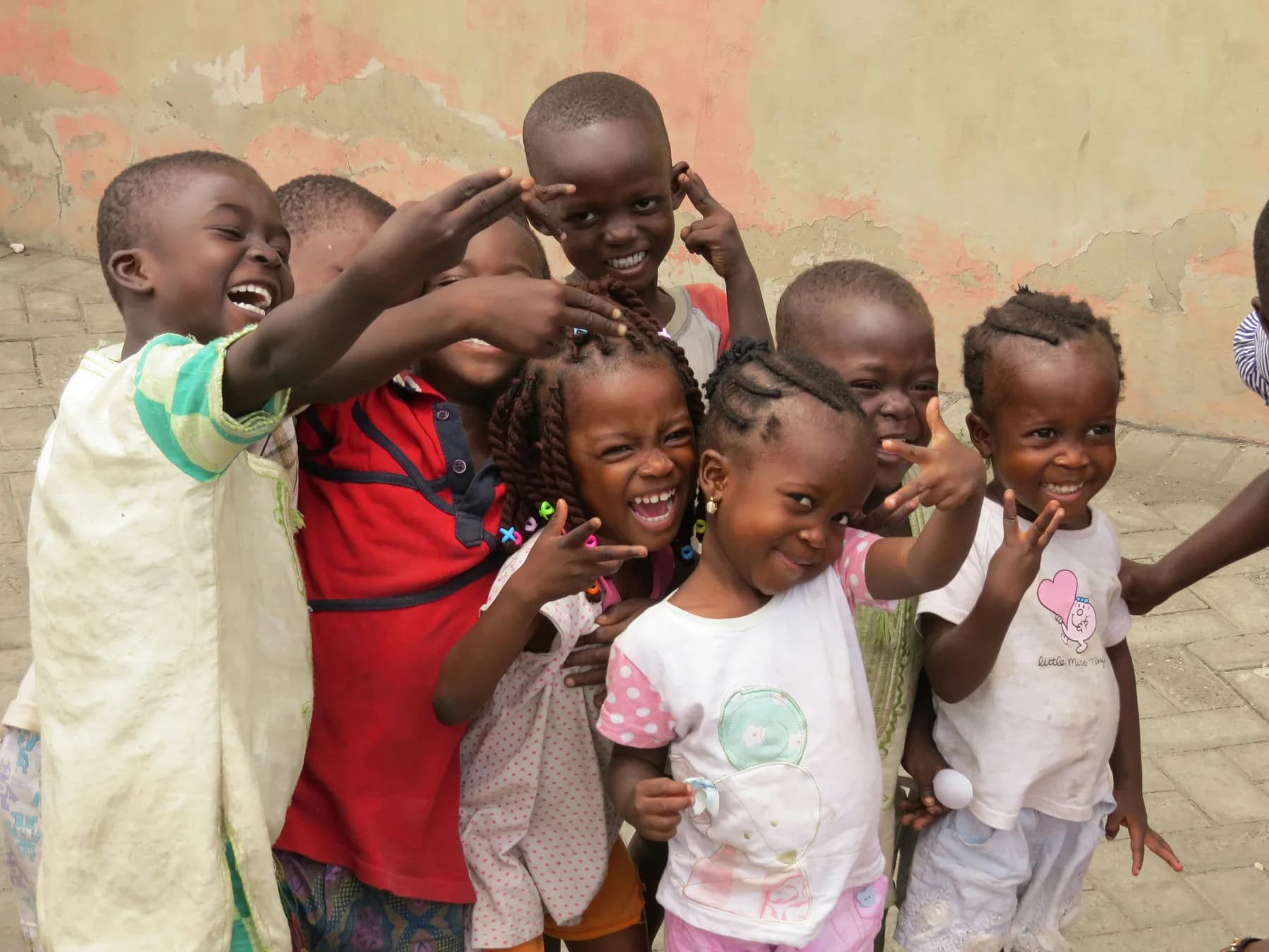 Children crowding together, laughing towards the camera