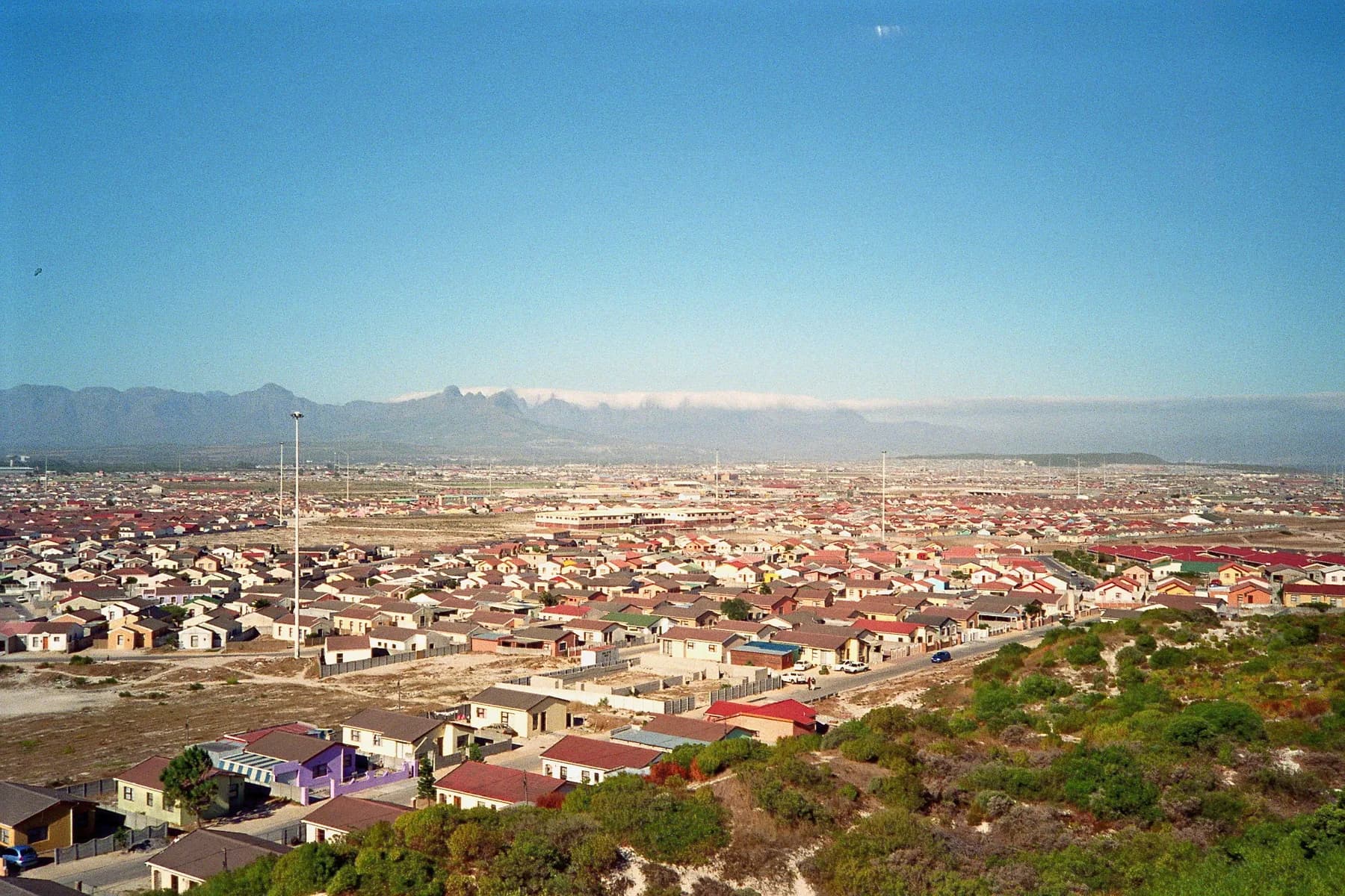 A township seen from a hill, houses running out to the horizon