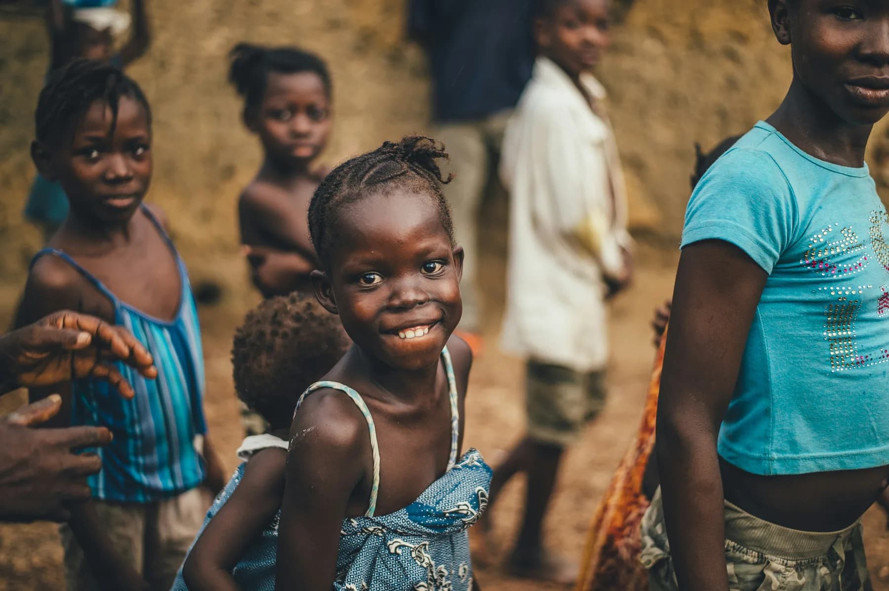 A girl smiling at the camera among a group of other children